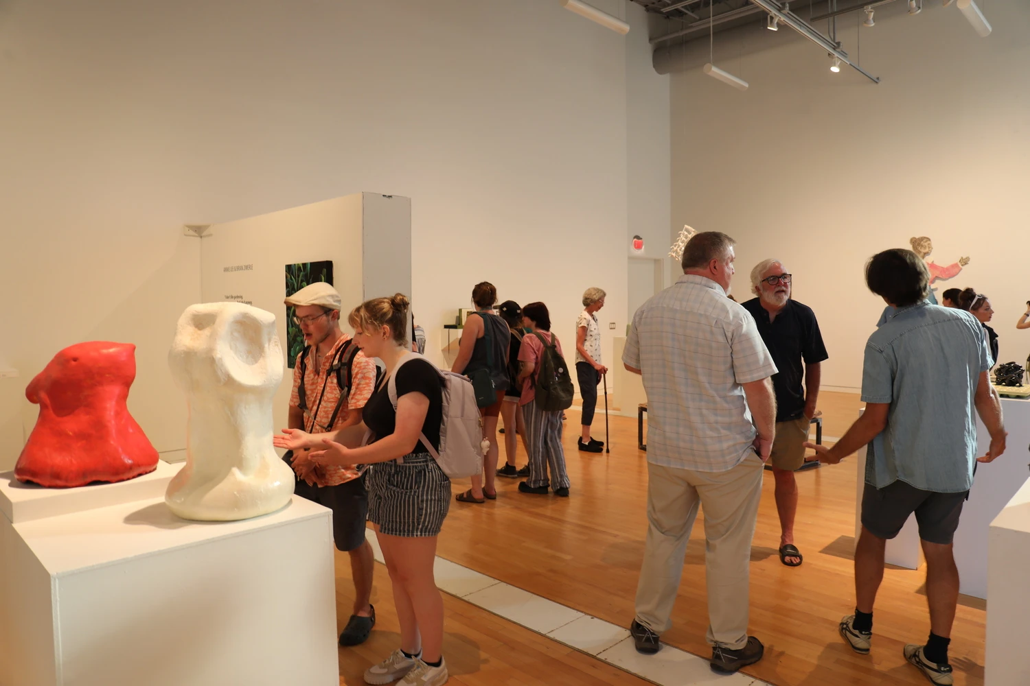 Group of Farmington community members gather at on-campus art gallery.