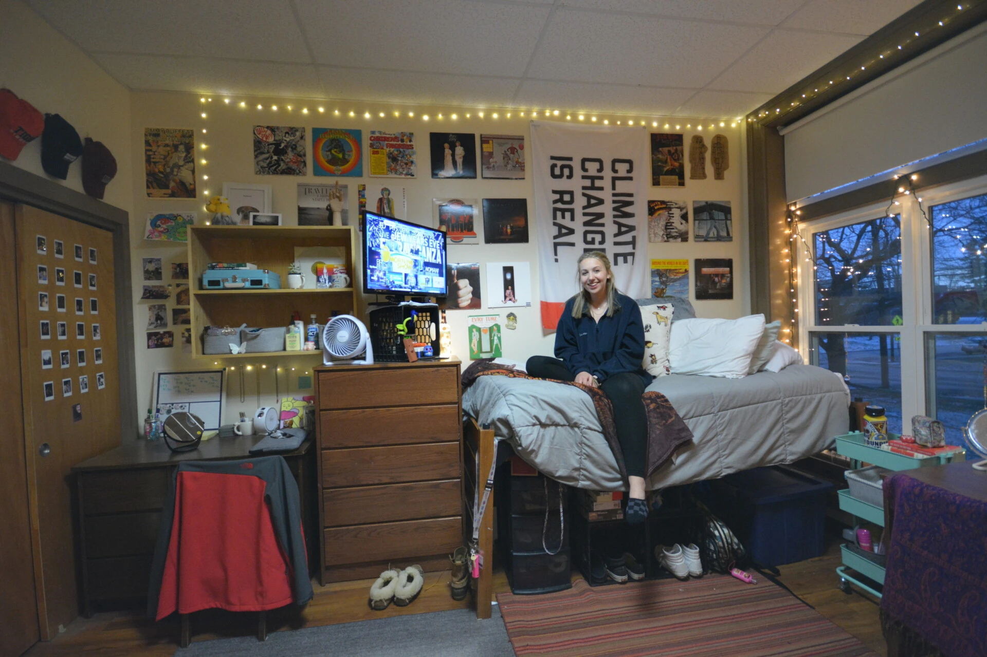 Farmington students sits on bed in dorm room