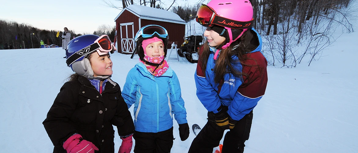 Alpine Operations student works with young skiers.