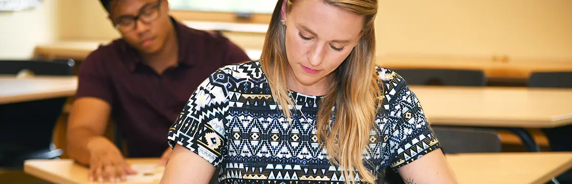 Graduate math education students reads textbook at desk