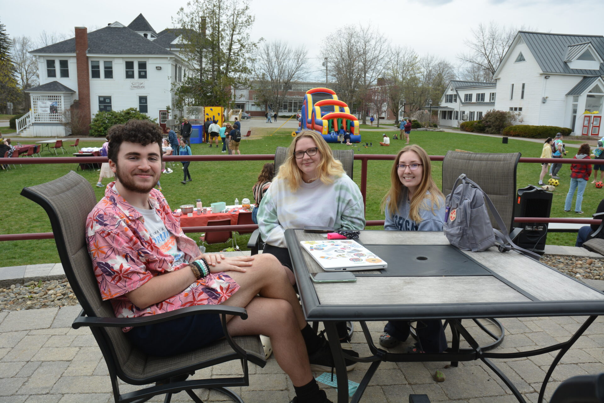 Three students sitting at a table outside the Library