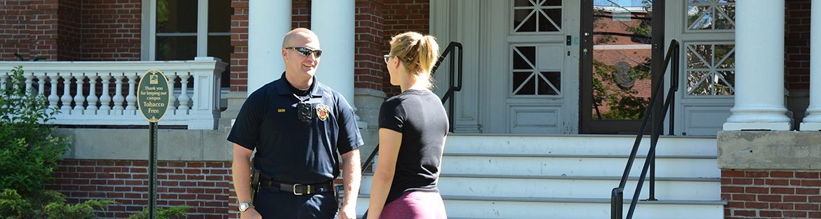 A student standing and speaking with a Campus Safety Officer