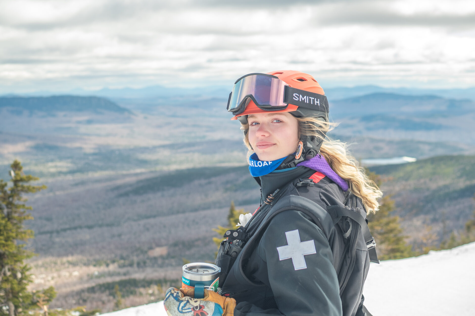 Leah, smiling and looking at the camera full dressed in her ski equipment.