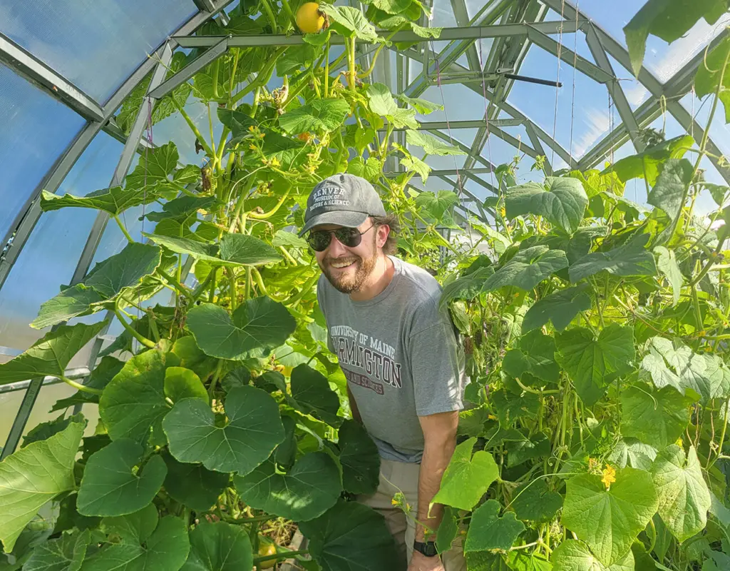 Larry Tuttle, garden director, in the garden's prolific greenhouse where squash, cucumbers, tomatoes, peppers and more are grown.